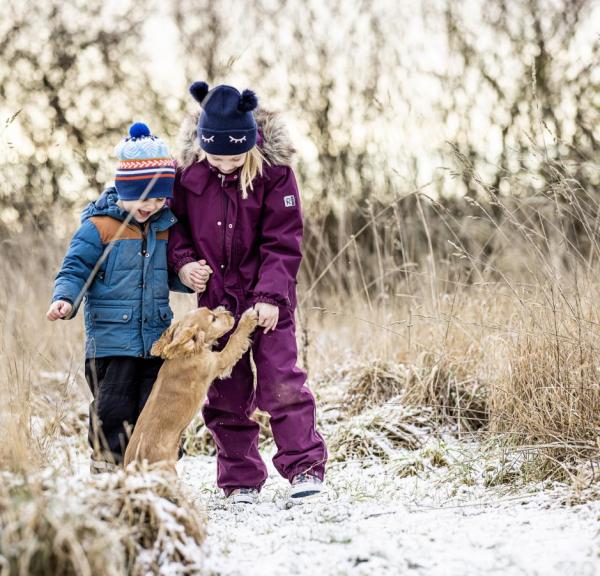 To børn og en hund i vinterlandskab